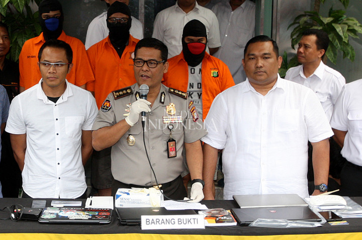 Polisi menghadirkan tersangka kasus ilegal akses terhadap sistem elektronik dihadirkan di Polda Metro Jaya, Jakarta. Polisi juga mengamankan 3 buah buku tabungan, 3 buah kartu ATM, dan perangkat internet.