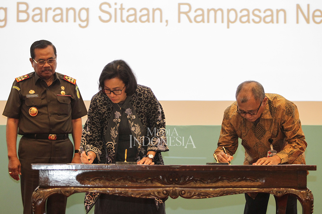 Jaksa Agung M Prasetyo, Menteri Keuangan Sri Mulyani, Ketua KPK Agus Rahardjo menyatukan tangan udalam acara penandatanganan kerja sama lelang barang sitaan, rampasan atau eksekusi dari perkara pidana di gedung Kementerian Keuangan, Jakarta. MI/Pius Erlangga