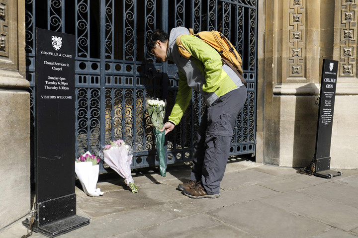 Seorang pria menaruh bunga dukacita atas meninggalnya Stephen Hawking di Universitas Cambridge.