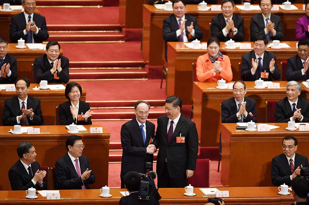 Xi Jinping (kanan) berjabat tangan dengan Wang Qishan yang terpilih secara mutlak sebagai Presiden dan Wapres Tiongkok dalam sidang parlemen (NPC) di Beijing, Sabtu, 17 Maret 2018.