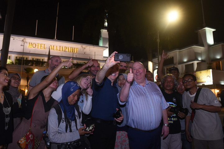 Walikota Liverpool Joe Anderson (ketiga kanan) bersama Wakil Walikota liverpool Gary Millar (tengah) berswafoto dengan latar Hotel Majapahit ketika berburu foto bersama komunitas fotografi di jalur pedesterian Jalan Tunjungan, Surabaya, Jawa Timur.