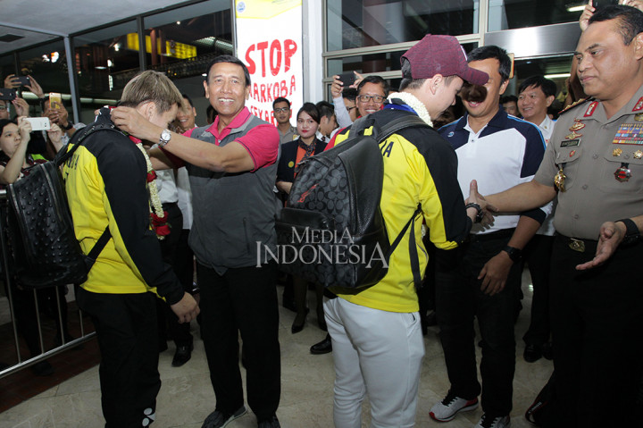 Ketua umum Persatuan Bulu Tangkis Seluruh Indonesia (PBSI) Jenderal Purn. Wiranto (kedua kiri) mengalungkan melati ke Marcus Gideon saat acara penyambutan juara All England 2018 di terminal kedatangan internasional 2D Bandara Soekarno Hatta, Tangerang. MI/Pius Erlangga