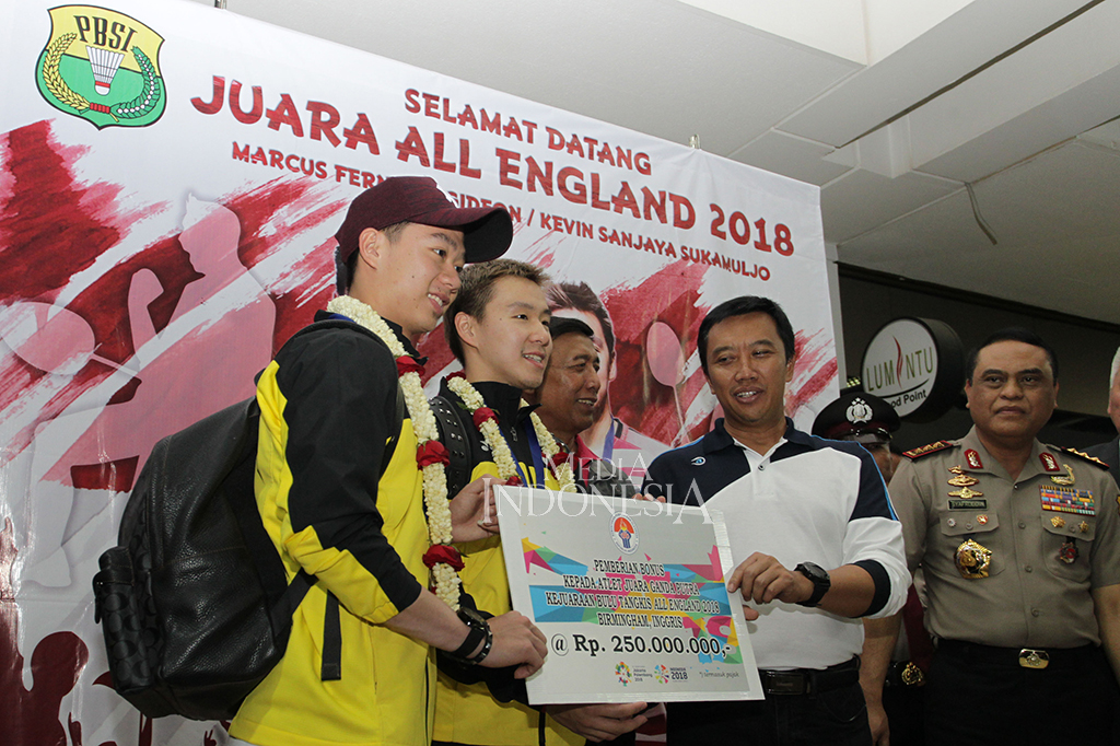 Pasangan ganda putra Indonesia Kevin Sanjaya (kiri), dan Marcus Gideon (tengah) menerima uang bonus dari Menteri Pemuda dan Olahraga Imam Nahrawi (kanan) saat acara penyambutan di terminal 2D kedatangan internasional, Bandara Soekarno Hatta, Tangerang, Banten. MI/Pius Erlangga