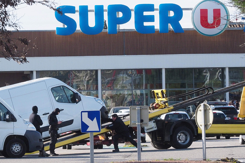 Penyandera itu awalnya membajak sebuah mobil di Carcassonne, kemudian membunuh seorang penumpang dan melukai pengemudinya, sebelum menembak seorang polisi yang sedang berlari-lari kecil bersama rekan-rekannya di dekatnya.