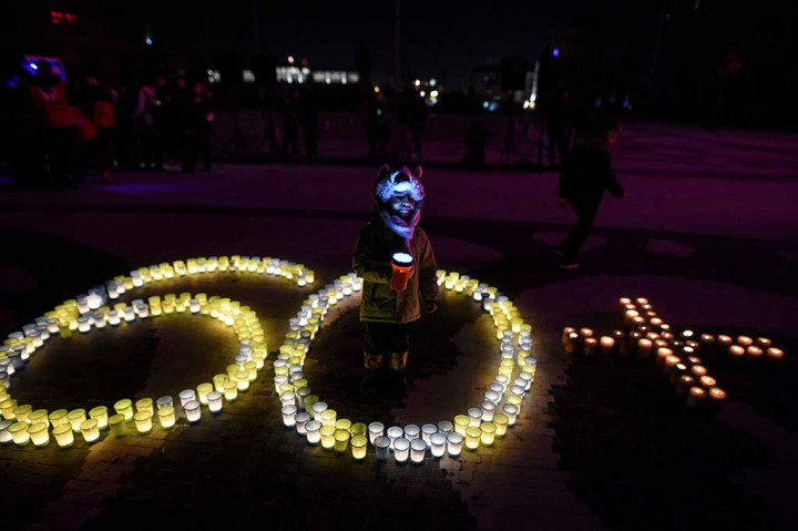 Aktivis LSM Palang Merah menyalakan lilin yang membentuk angka '60 +', selama peringatan Earth Hour di alun-alun utama Skopje, Macedonia. AFP/Robert Atanasovski