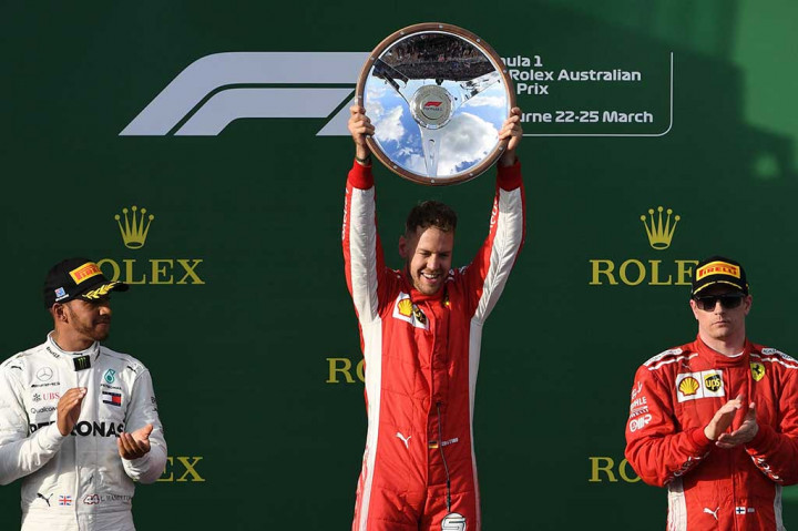 Pembalap Ferrari asal Jerman Sebastian Vettel mengangkat trofi usai memastikan diri menjadi juara Grand Prix Formula1 Australia di Melbourne, Minggu, 25 Maret 2018.
