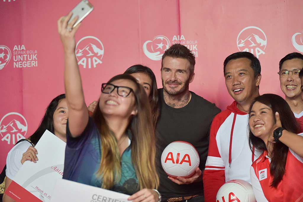 Beckham melayani permintaan foto dari para penggemarnya.
