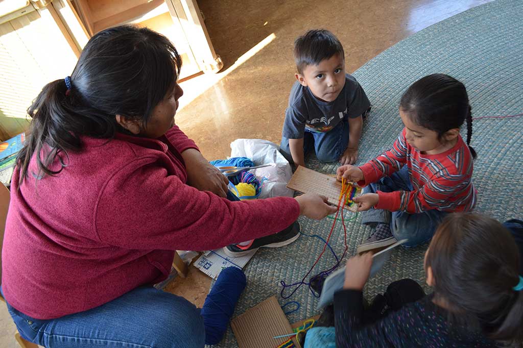 Seorang guru taman kanak-kanak mengajarkan murid-muridnya teknik menenun tradisional di Sekolah STAR, sebuah fasilitas pendidikan Navajo di Leupp, Arizona, AS, Jumat, 23 Maret 2018. 