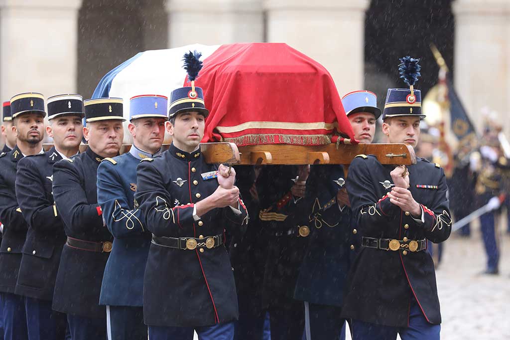 Penghormatan untuk Beltrame dimulai dengan mengheningkan cipta satu menit di barak polisi di seluruh Prancis, sebelum peti jenazah tertutup bendera triwarna yang dipegang polisi diangkat ke lapangan upacara di Hotel des Invalides, bekas rumah sakit militer. AFP/Ludovic Marin