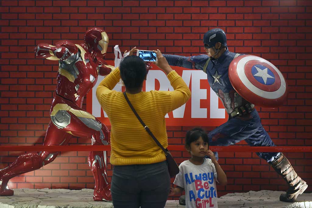 Pengunjung mengambil gambar 'action figure superhero' Marvel, Iron Man dan Captain America, yang dipamerkan pada Experience Marvel Universe Exhibition di Tunjungan Plaza, Surabaya, Jawa Timur, Rabu, 28 Maret 2018. 