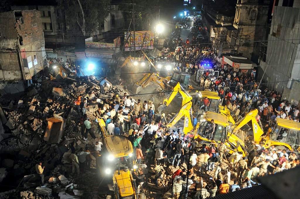 Belum diketahui penyebab pasti kejadian tersebut, namun media lokal India menyebut gedung itu runtuh setelah ditabrak alat berat.