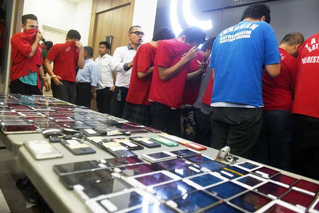 Sejumlah tersangka beserta barang bukti ditampilkan saat rilis kasus dugaan tindak pidana memanipulasi informasi dan transaksi elektronik di Polrestabes Surabaya, Jawa Timur, Senin, 2 April 2018. Polisi menangkap 16 pengemudi taksi online yang memanipulasi data dengan order fiktif.