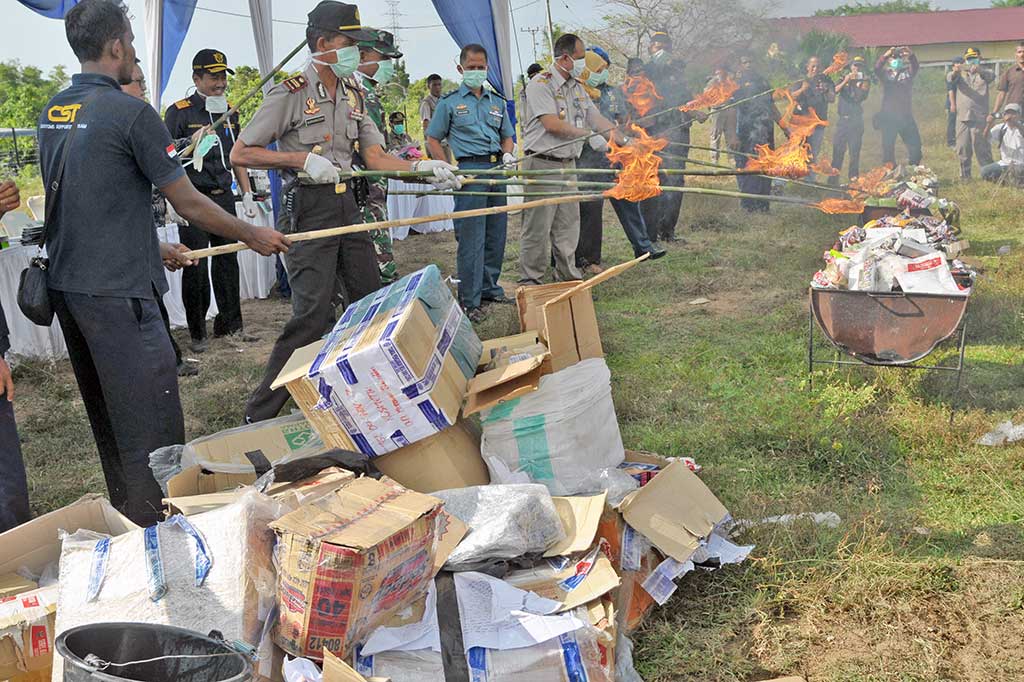 Petugas gabungan Bea dan Cukai, Karantina Pertanian, BPOM, Kejaksaan, Polisi dan TNI, memusnahkan sejumlah produk impor ilegal dengan cara dibakar, di Desa Samahani, Kabupaten Aceh Besar, Aceh, Selasa, 3 April 2018. 