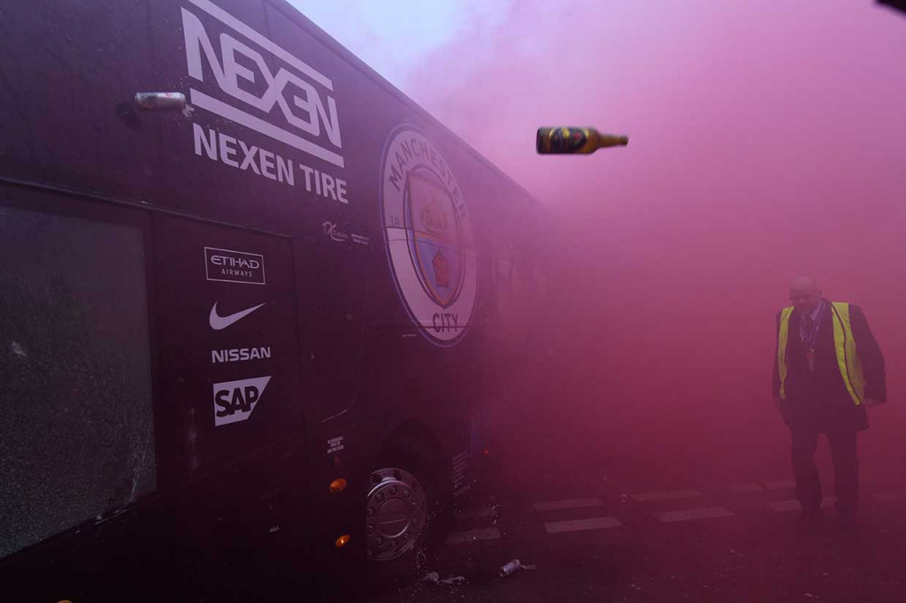 Botol dan kaleng minuman dilemparkan ke arah bus yang mengangkut para pemain Manchester City saat tiba di Stadion Anfield, Kamis, 5 April 2018 dini hari WIB.