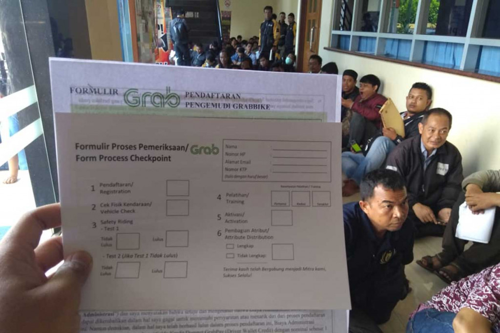Pengemudi ojek online Uber berbondong-bondong melakukan pendaftaran verifikasi dokumen ke Grabbike di GOR Bendungan Hilir, Jakarta, pada Jumat, 6 April 2018. 