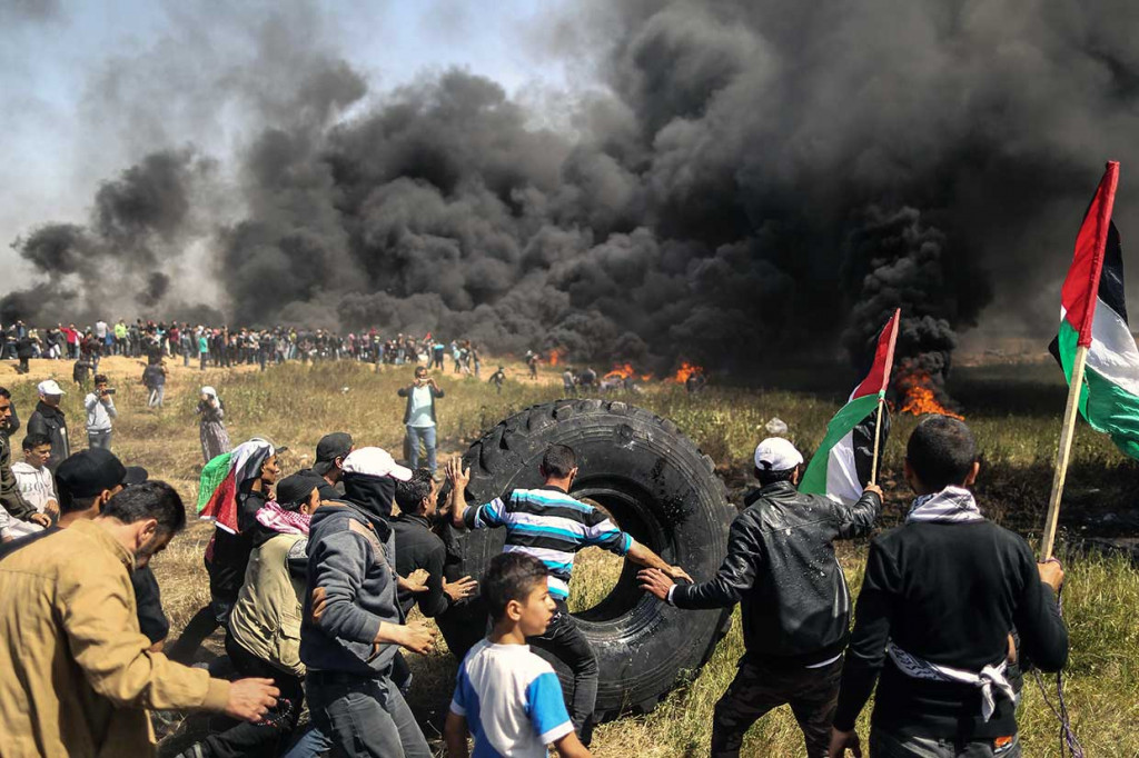 Ribuan demonstran Palestina memulai aksi mereka pada Jumat pagi dengan membakar puluhan ban mobil bekas di dekat perbatasan antara bagian timur Jalur Gaza dan Israel dalam upaya membuat tameng asap hitam guna melindungi diri mereka dari tembakan tentara Israel.