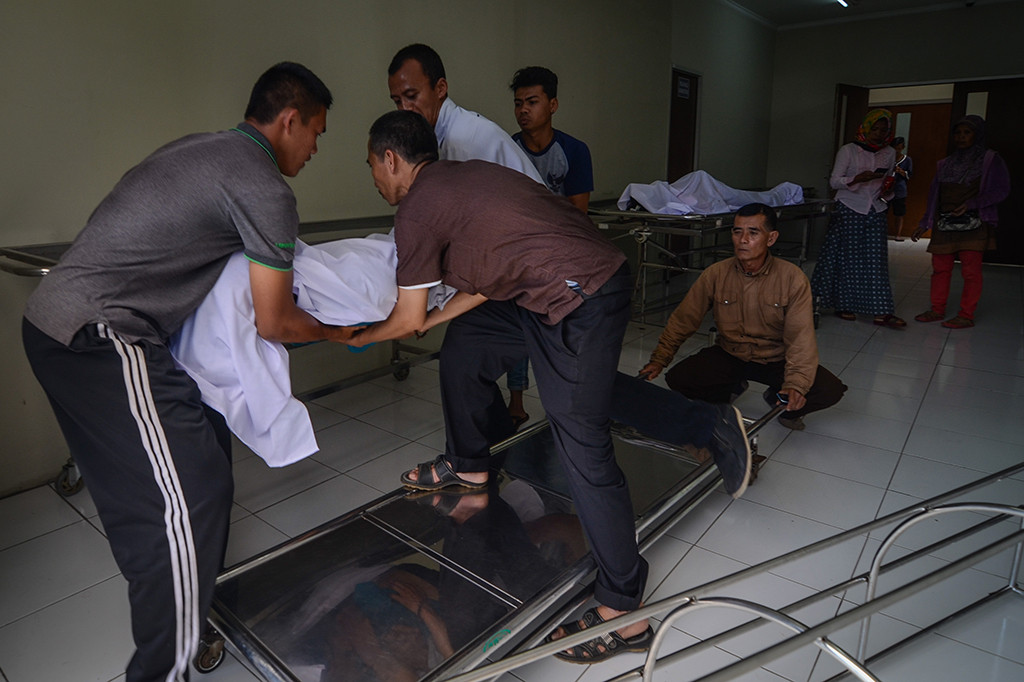 Keluarga memindahkan jenazah korban meninggal akibat keracunan minuman keras (miras) oplosan ke dalam mobil ambulans di Rumah Sakit Umum Daerah (RSUD) Cicalengka, Kabupaten Bandung, Jawa Barat.