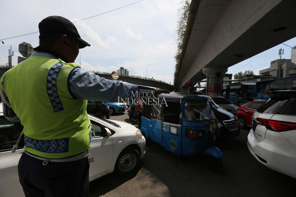 Petugas mengatur arus kendaraan yang terjebak kemacetan saat rekayasa lalu lintas pada uji coba lintas bawah atau underpass Matraman, Selasa, 10 April 2018. MI/Ramdani