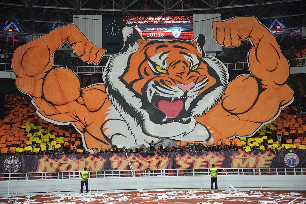 Suporter Persija Jakarta membentangkan karakter macan saat menyaksikan laga lanjutan Piala AFC Persija Jakarta melawan Johor Darul Ta'zim (JDT) di Stadion Utama Gelora Bung Karno, Senayan, Jakarta.