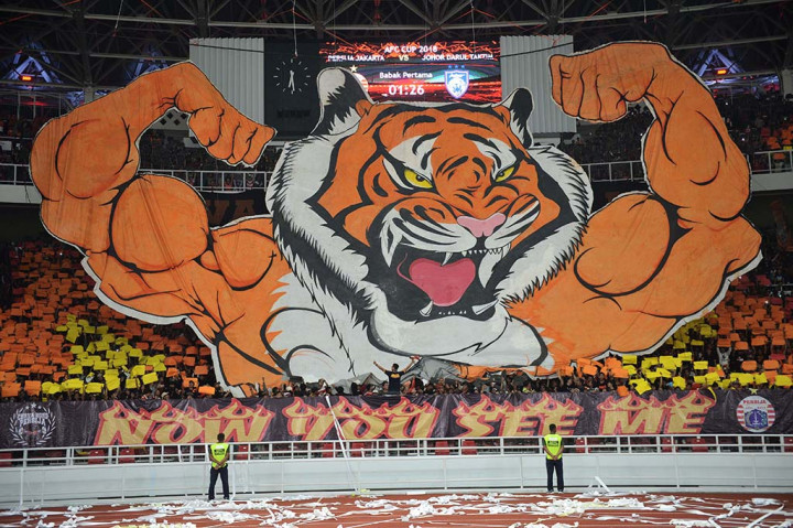 Suporter Persija Jakarta membentangkan karakter macan saat menyaksikan laga lanjutan Piala AFC Persija Jakarta melawan Johor Darul Ta'zim (JDT) di Stadion Utama Gelora Bung Karno, Senayan, Jakarta.
