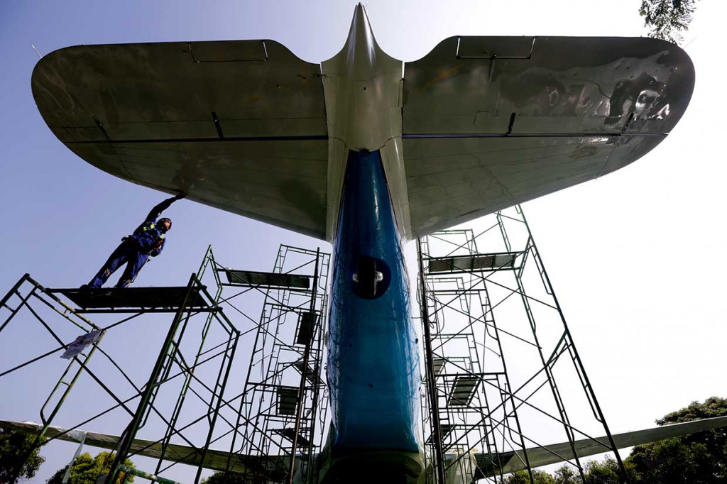 Pekerja PT Garuda Maintenance Facility (GMF) Aero Asia bersama siswa SMK Penerbangan Banda Aceh memperbaiki replika pesawat Dakota RI 001 di Banda Aceh, Aceh, Kamis, 12 April 2018.