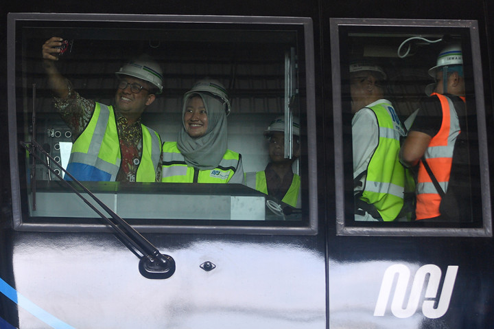 Gubernur DKI Jakarta Anies Baswedan (kiri) bersama anaknya Kaisar Hakam (ketiga kiri) melakukan swafoto dengan masinis perempuan MRT, Tiara (kedua kiri), saat meninjau kepala kereta MRT di Depo MRT Lebak Bulus, Jakarta. Dua set rangkaian kereta MRT telah berada di Depo Lebak Bulus dan akan dilakukan serangkaian tes serta persiapan sebelum diujicobakan pada Desember 2018.