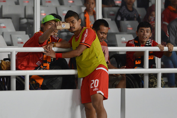 Pesepak bola Persija Jakarta Bambang Pamungkas berswafoto dengan penonton difabel sebelum pertandingan Persija Jakarta melawan Borneo FC dalam pertandingan Gojek Liga 1 2018 di Stadion Utama Gelora Bung Karno, Jakarta.

