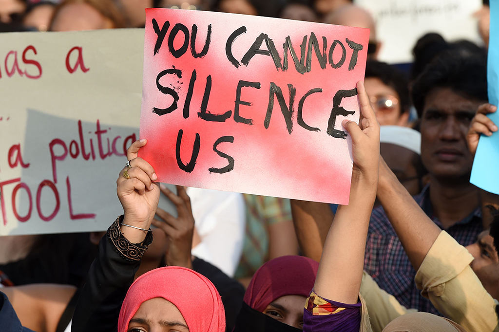 Seorang demonstran memegang poster bertuliskan 'Anda tidak bisa membungkam kami' dalam aksi protes di Mumbai. AFP/PUNIT PARANJPE