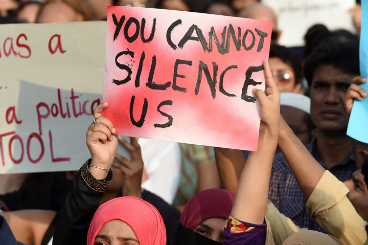 Seorang demonstran memegang poster bertuliskan 'Anda tidak bisa membungkam kami' dalam aksi protes di Mumbai. AFP/PUNIT PARANJPE