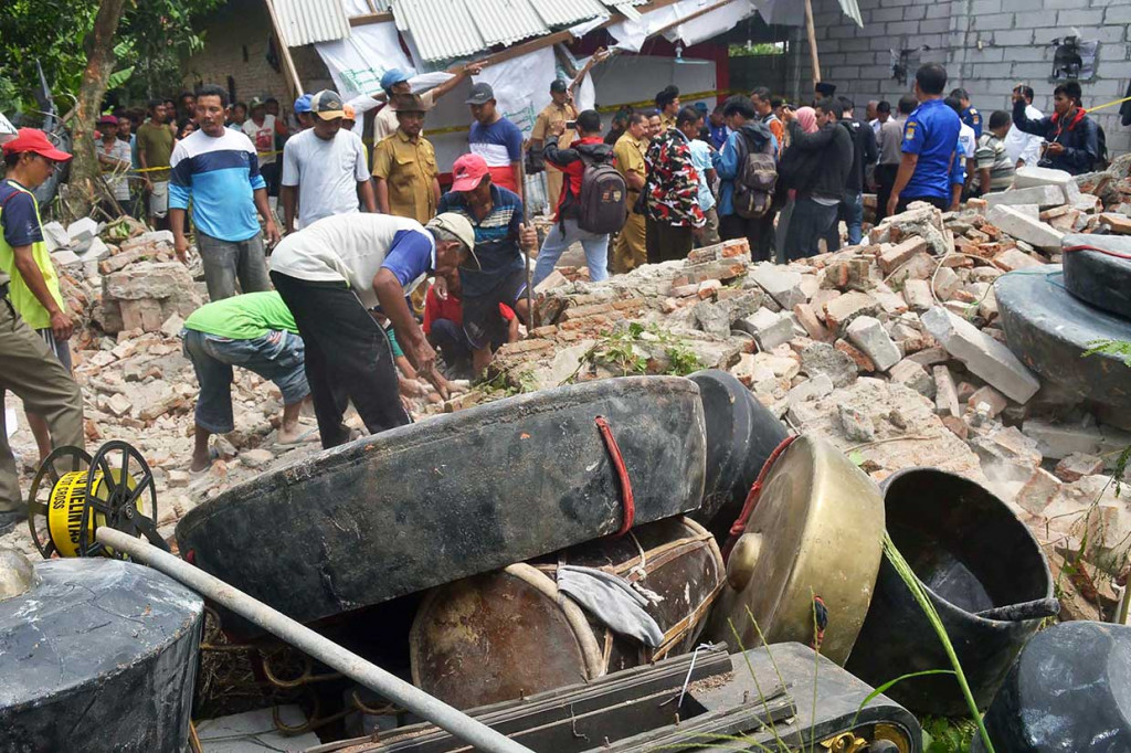 Warga memindahkan material bangunan tembok sarang burung walet yang roboh di Desa Gegesik Wetan, Kecamatan Gegesik, Cirebon, roboh, Senin, 16 April 2018. 