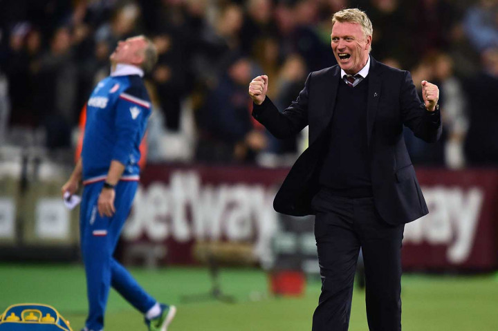 Ekspresi berbeda diperlihatkan pelatih West Ham David Moyes dan pelatih Stoke Paul Lambert setelah gol Carroll.