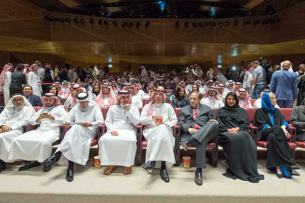 Menteri Penerangan dan Kebudayaan Arab Saudi Awwad Alawwad (tengah) bersiap menonton film 'Black Panther' sambil menikmati popcorn. 