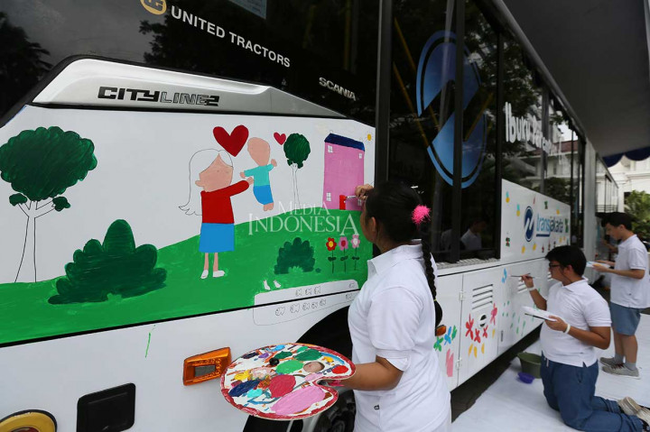 Sebanyak 10 anak berkebutuhan khusus melukis dengan kanvas bodi sebuah bus TransJakarta di halaman Balai Kota DKI Jakarta, Jumat, 20 April 2018.
