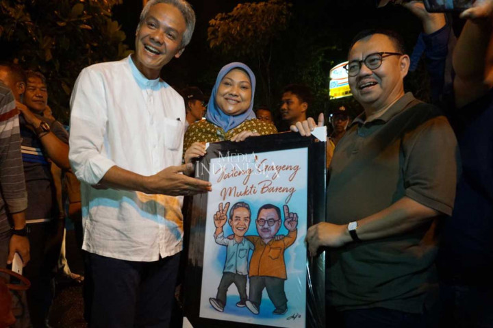 Cagub Jateng Ganjar Pranowo memberi hadiah berupa karikatur kepada Sudirman Said yang merayakan ulang tahun ke-55 saat memenuhi undangan makan bersama rivalnya tersebut di sebuah warung angkringan di Jalan Pamul, Semarang, Kamis, 19 April 2018 malam.