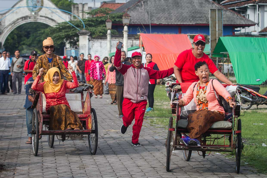 Wanita dari Komunitas Pejalan Kaki (KPK) Solo beradu cepat mengayuh becak pada Lomba Balap Becak Ibu-Ibu di Alun-alun Kidul, Solo, Jawa Tengah. ANTARA/Mohammad Ayudha
