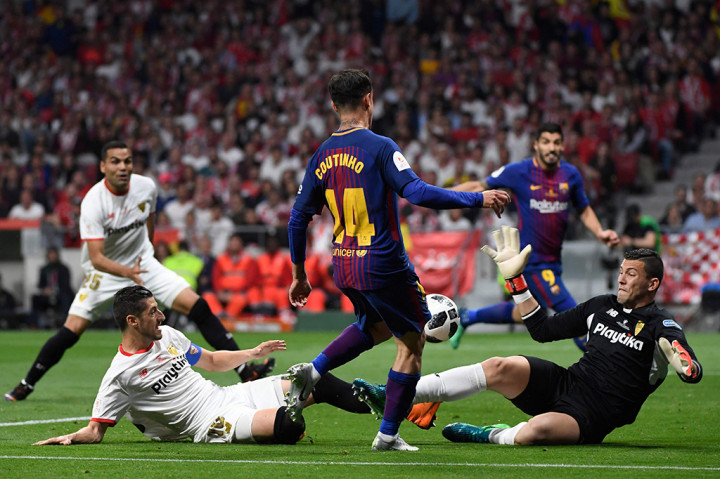Pada menit ke-69, Sevilla kian terpuruk setelah terkena hukuman penalti akibat handball yang dilakukan Clement Lenglet. Coutinho yang menjadi algojo, tak menyia-nyiakan kesempatan emas itu. AFP/ PIERRE-PHILIPPE MARCOU
