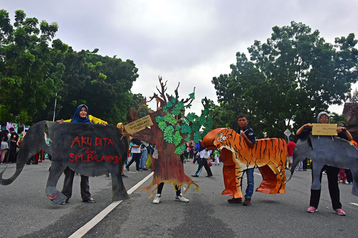 Sejumlah akitivis lingkungan dari Rimba Satwa Foundation mengenakan replika gajah dan harimau Sumatera untuk memperingati Hari Bumi (Earth Day) di Kota Pekanbaru, Riau. ANTARA/FB Anggoro