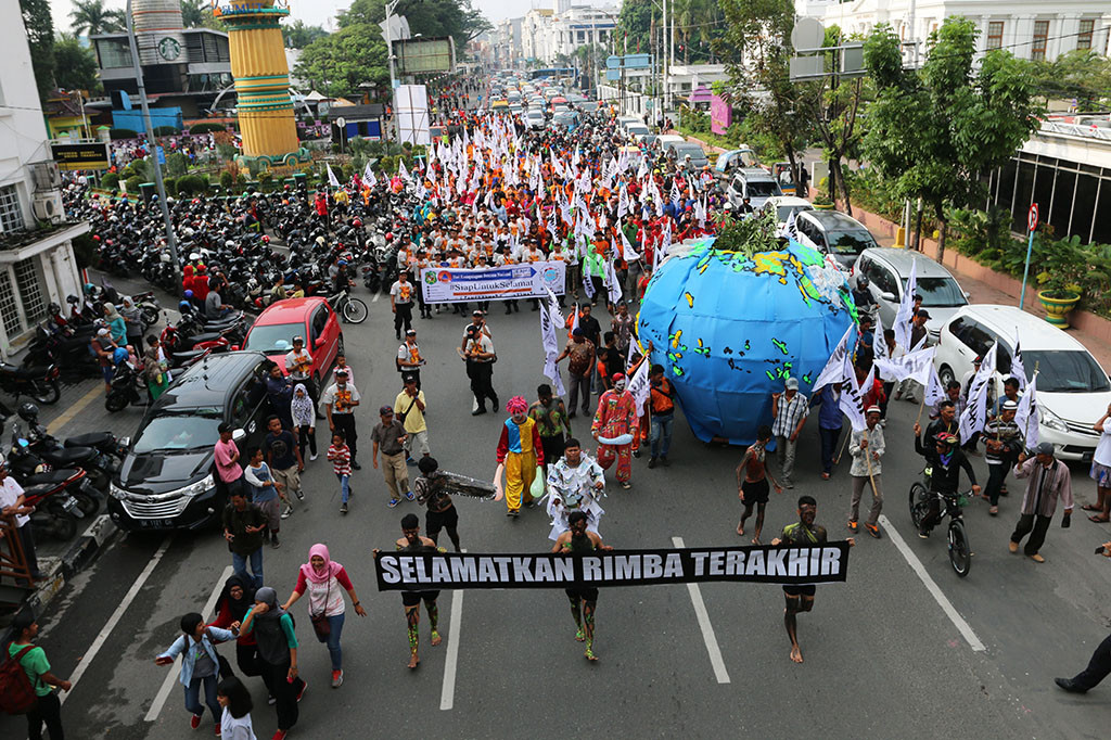 Aktivis Wahana Lingkungan Hidup Indonesia (Walhi) memegang spanduk dan mengarak bola dunia ketika memperingati Hari Bumi, di Medan, Sumatera Utara. Kegiatan mengajak masyarakat untuk bersama peduli terhadap lingkungan hidup tersebut mengkampanyekan 