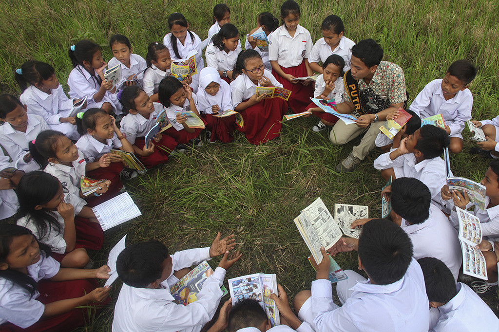 Sejumlah siswa SD membaca buku bersama di pematang sawah di kawasan Kadipiro, Solo, Jawa Tengah. ANTARA/Maulana Surya