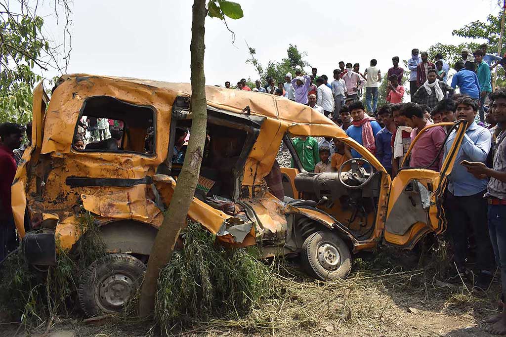 Warga berkerumun di dekat bus sekolah yang ringsek setelah dihantam sebuah kereta di Distrik Kushinagar, Negara Bagian Uttar Pradesh, India, Kamis 26 April 2018.
