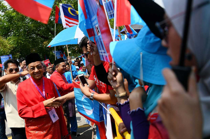 Sementara mantan PM Malaysia dari oposisi Pakatan Harapan Mahathir Mohamad juga mendaftar dengan disambut para pendukungnya. Saat pendaftaran berlangsung, depan Dewan MPAJ ditutup polisi. Massa
yang berasal dari Barisan Nasional, koalisi Pakatan Harapan, dan Partai Islam Malaysia (PAS) ditempatkan terpisah. AFP/Manan Vatsyayana