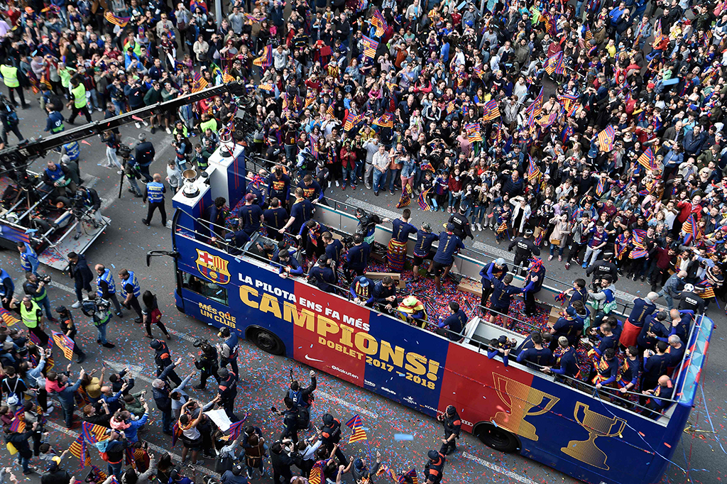 Ribuan fan menyambut gembira perayaan klub yang dihiasi warna biru merah khas kostum Barcelona dan warna kuning merah warna bendera Catalonia.