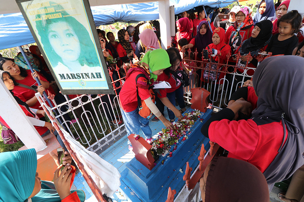 Sejumlah buruh menabur bunga di atas makam Marsinah di Desa Nglundo, Nganjuk, Jawa Timur. Ribuan buruh dari sejumlah daerah melakukan ziarah di makam pejuang buruh Marsinah guna memperingati Hari Buruh Internasional. ANTARA/Prasetia Fauzani