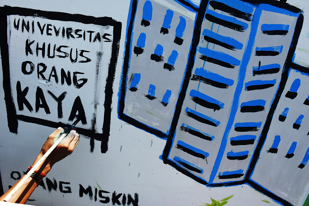 Mahasiswa membuat mural terkait pendidikan dalam rangka memperingati Hari Pendidikan Nasional (Hardiknas) di depan kampus Universitas Muhammadiyah (Unismuh) Makassar, Sulawesi Selatan. Aksi pembuatan mural tersebut sebagai bentuk kritik terhadap sistem pendidikan di Indonesia. ANTARA/Yusran Uccang
