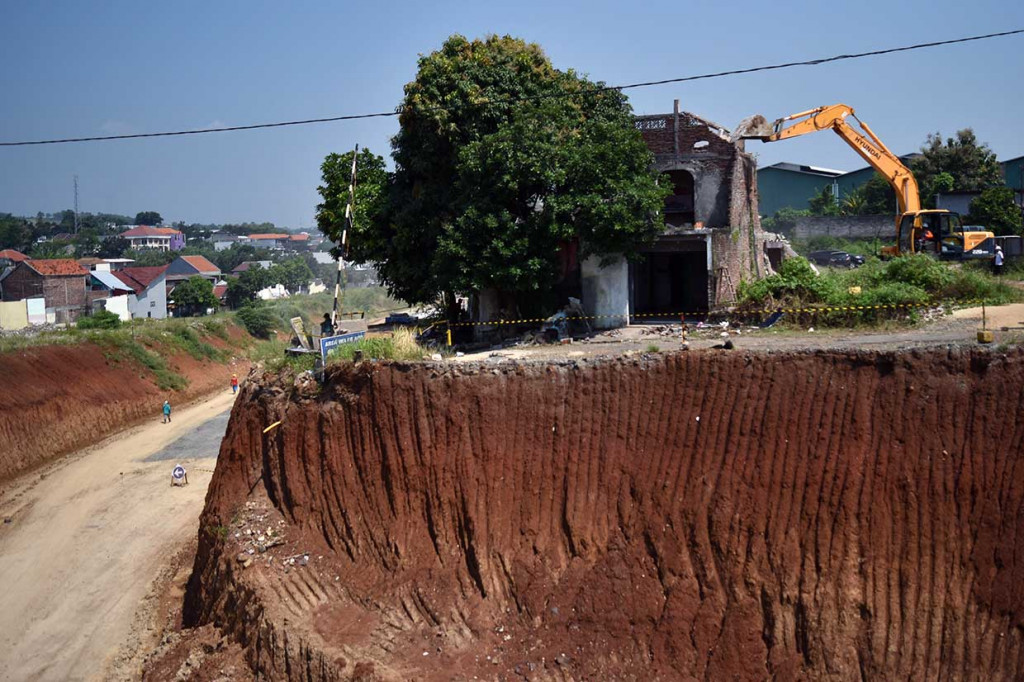 Pekerja mengoperasikan alat berat untuk merobohkan rumah yang dieksekusi di lahan pembangunan Tol Semarang-Batang di Tambakaji, Ngaliyan, Semarang, Jawa Tengah, Kamis, 3 Mei 2018.