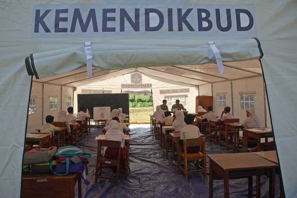 Siswa SDN Kasinoman mengikuti USBN di tenda darurat di lokasi bencana gempa bumi Desa Kasinoman, Kalibening, Banjarnegara, Jateng. USBN hari pertama di Kalibening diwarnai gempa susulan sehingga membuat panik siswa. ANTARA/Anis Efizudin