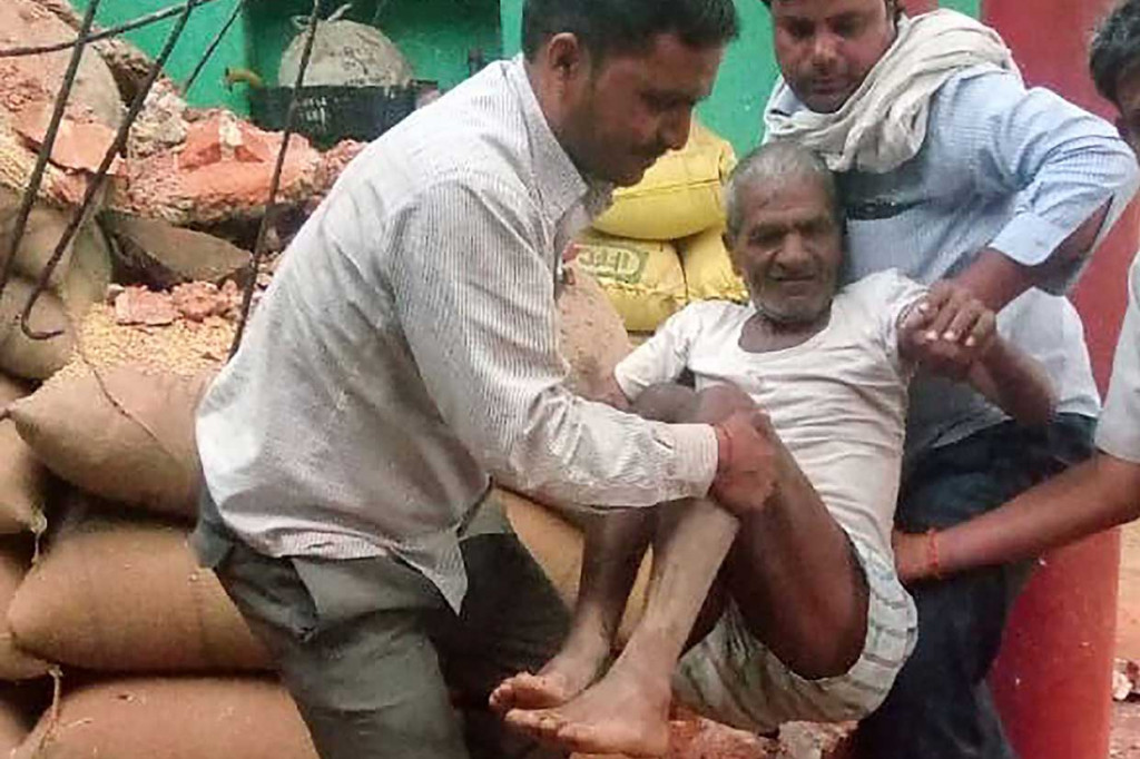 Seorang warga dievakuasi dari reruntuhan rumahnya yang rusak menyusul badai debu di Etmadpur, Agra, India, Kamis, 3 Mei 2018. 