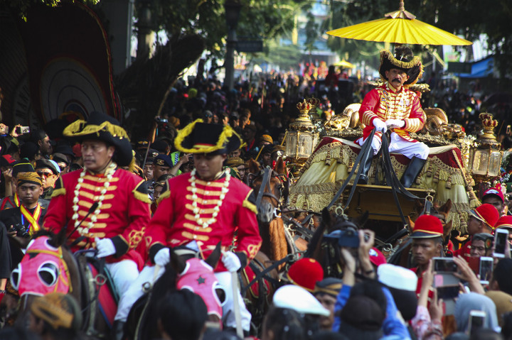 Dalam Kirab Agung Solo itu Raja Solo, PB XIII bersama keluarga menyapa warga Solo dan menyebar koin atau udik-udik.