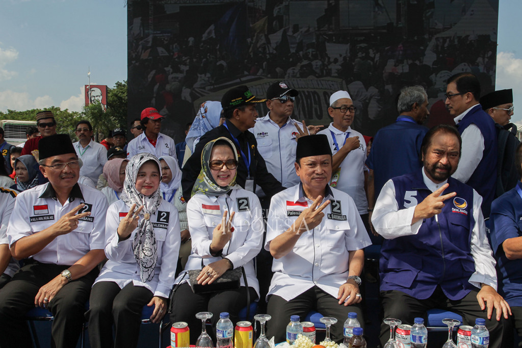 Ketua Umum Partai NasDem Surya Paloh (kanan) berfoto bersama dengan pasangan calon Walikota dan Wakil Walikota Palembang, Sarimuda (kedua kanan) dan Abdul Rozak (kiri) saat kampanye terbuka calon Walikotan dan Wakil Walikota di Benteng Kota Besak, Palembang, Sumatera Selatan.
