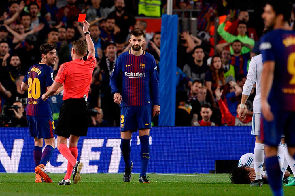 Tuan rumah harus bermain dengan 10 orang pada akhir babak pertama setelah Sergi Roberto diganjar kartu merah wasit akibat memukul Marcelo. AFP/JOSEP LAGO